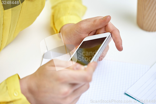 Image of close up of female hands with smartphone at home