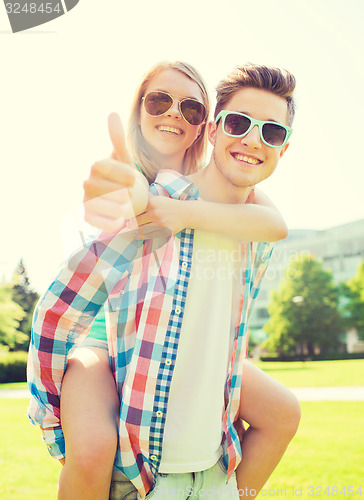 Image of smiling couple having fun and showing thumbs up