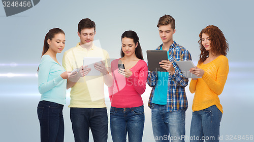 Image of group of teenagers with smartphones and tablet pc