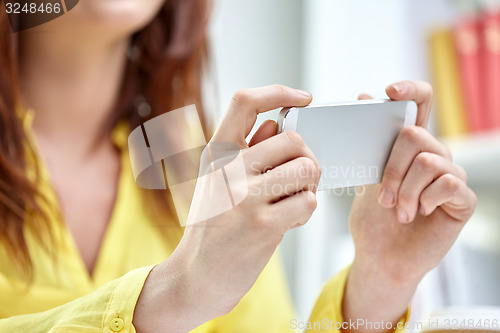 Image of close up of female hands with smartphone at home