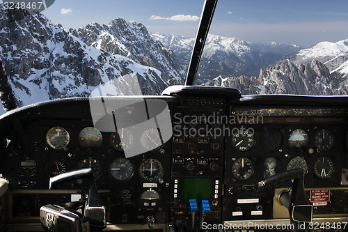 Image of dashboard in airplane cockpit and mountains view