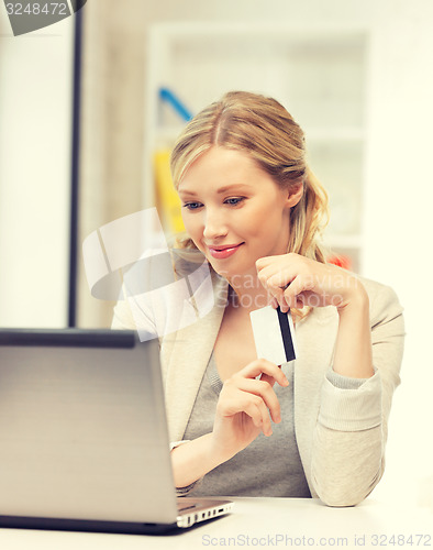 Image of happy woman with laptop computer and credit card