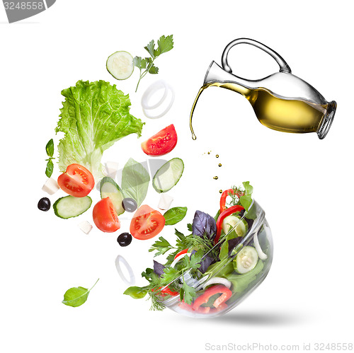 Image of Falling vegetables for salad and oil isolated