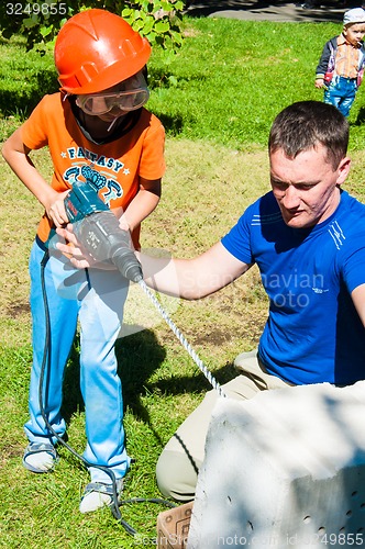 Image of A child learns to work with electric drill