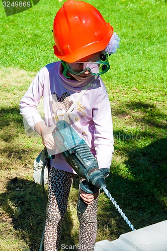 Image of A child learns to work with electric drill