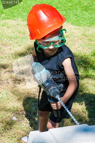 Image of A child learns to work with electric drill