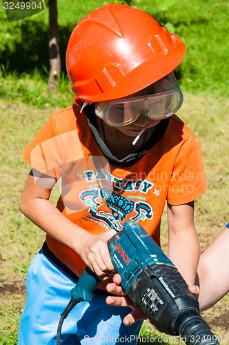 Image of A child learns to work with electric drill