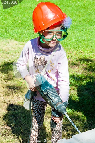 Image of A child learns to work with electric drill