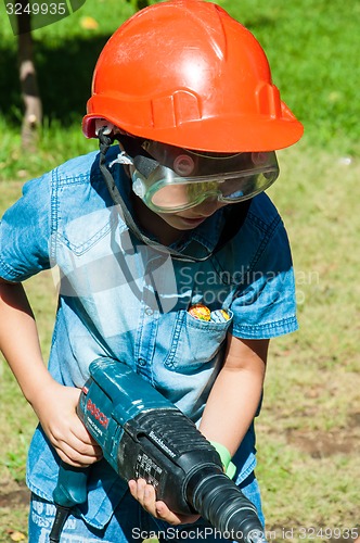 Image of A child learns to work with electric drill