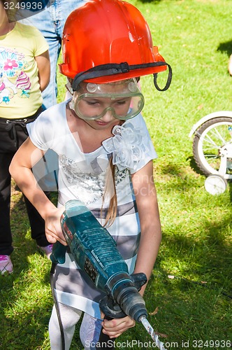 Image of A child learns to work with electric drill