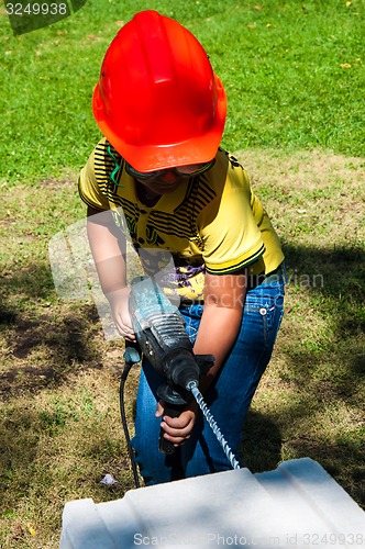 Image of A child learns to work with electric drill