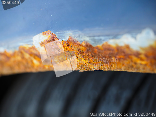 Image of Extreme closeup of orange and brown rust on vehicle over wheel