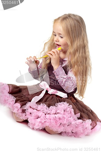 Image of Girl in tutu skirt playing with party blower