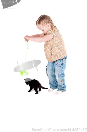 Image of Happy kid girl playing with black cat kitten