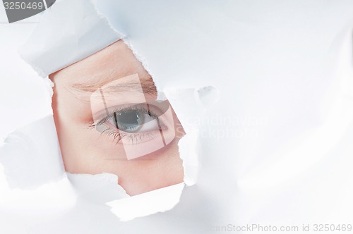 Image of Cute baby girl looking through paper hole 