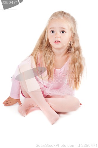 Image of Ballerina in pink dress sitting on the floor
