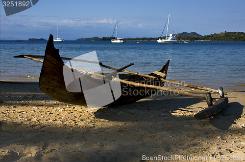 Image of  rock stone branch yacht boat palm lagoon and coastline