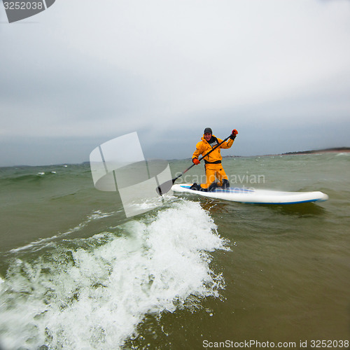 Image of Woman stand up paddle boarding