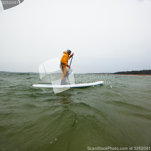 Image of Woman on a stand up paddle