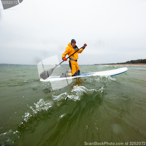 Image of Woman stand up paddle boarding