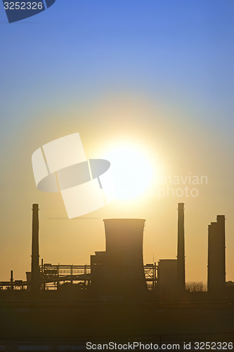 Image of silhouette of industrial factory at sunset