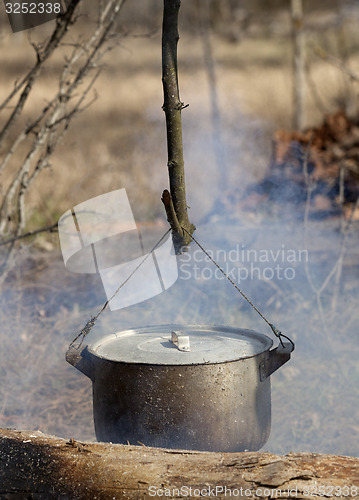 Image of Cooking in sooty cauldron on campfire