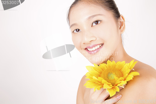 Image of Beautiful young Asian girl with bright yellow sunflower