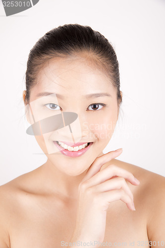 Image of Beautiful young Asian girl with one hand on face