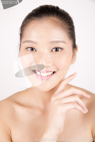 Image of Beautiful young Asian girl with one hand on face