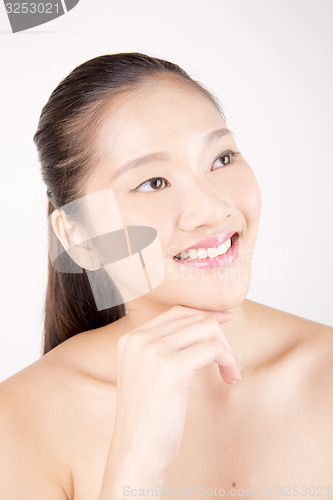 Image of Beautiful young Asian girl with one hand on face