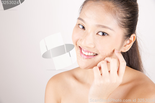 Image of Beautiful young Asian girl with one hand on face