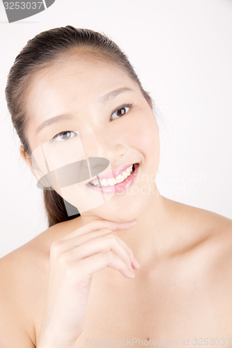 Image of Beautiful young Asian girl with one hand on face