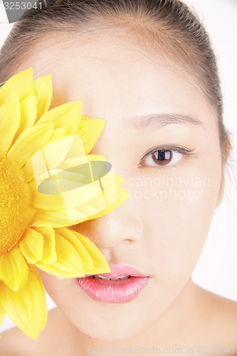 Image of Beautiful young Asian girl with bright yellow sunflower