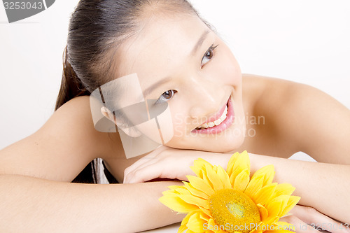 Image of Beautiful young Asian girl with bright yellow sunflower