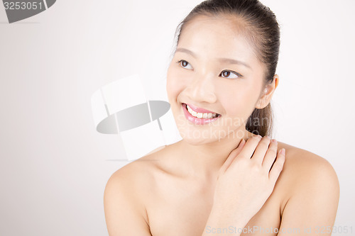 Image of Beautiful young Asian girl with one hand on shoulder