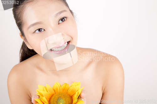 Image of Beautiful young Asian girl with bright yellow sunflower