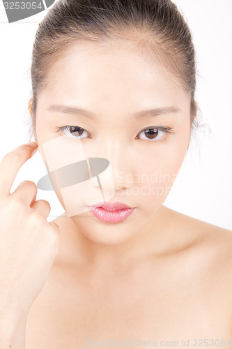 Image of Beautiful young Asian girl with one hand on face
