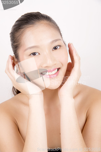 Image of Beautiful young Asian girl with both hands on face