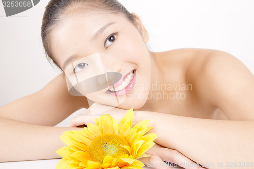 Image of Beautiful young Asian girl with bright yellow sunflower