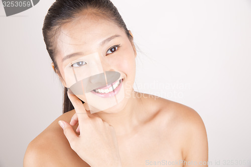 Image of Beautiful young Asian girl with one hand on face