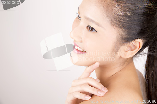 Image of Beautiful young Asian girl with one hand on shoulder