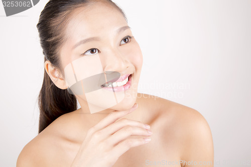 Image of Beautiful young Asian girl with one hand on face
