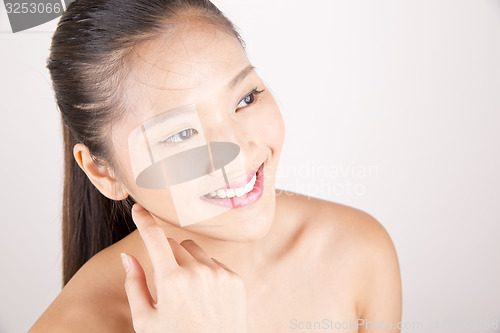 Image of Beautiful young Asian girl with one hand on face