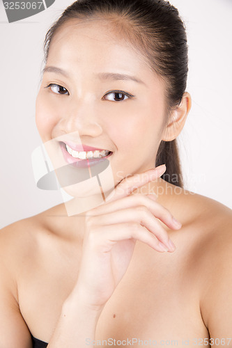 Image of Beautiful young Asian girl with one hand on face