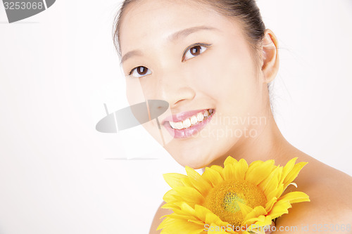 Image of Beautiful young Asian girl with bright yellow sunflower