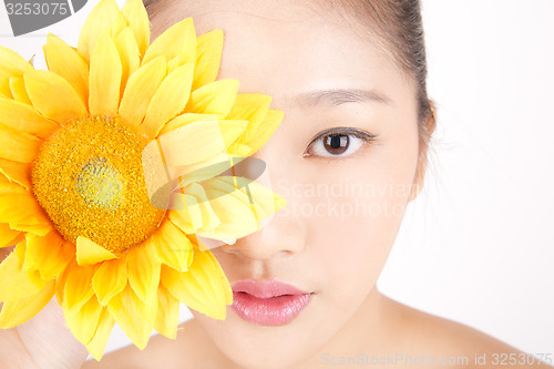 Image of Beautiful young Asian girl with bright yellow sunflower