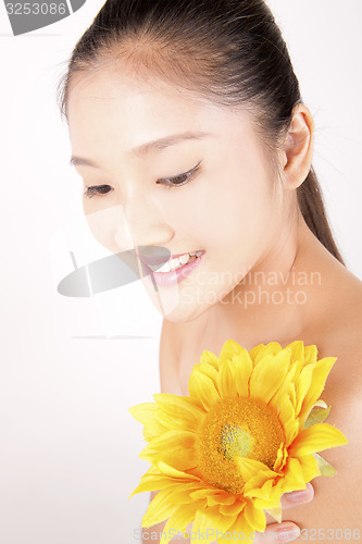 Image of Beautiful young Asian girl with bright yellow sunflower