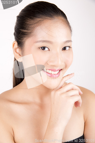 Image of Beautiful young Asian girl with one hand on face