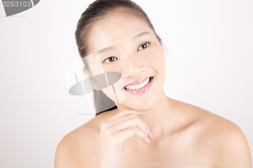 Image of Beautiful young Asian girl with one hand on face