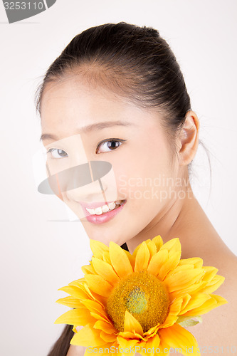 Image of Beautiful young Asian girl with bright yellow sunflower